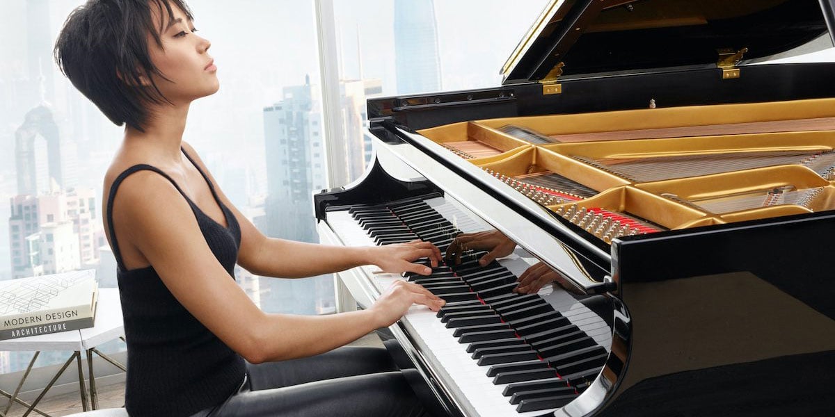 Person Sitting Down And Playing A Piano