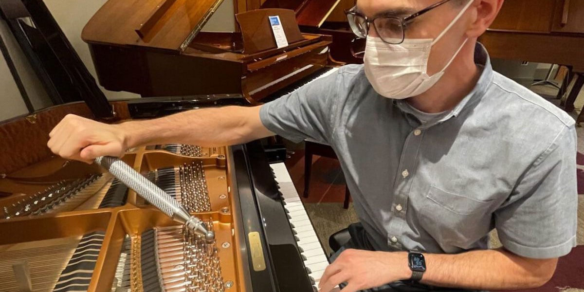 Person Performing Maintenance On Piano