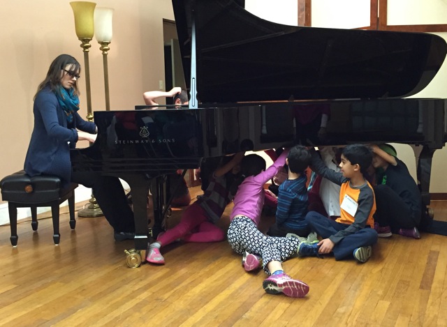 Student Under Piano Listening To Teacher Victoria Suchodoloski Play